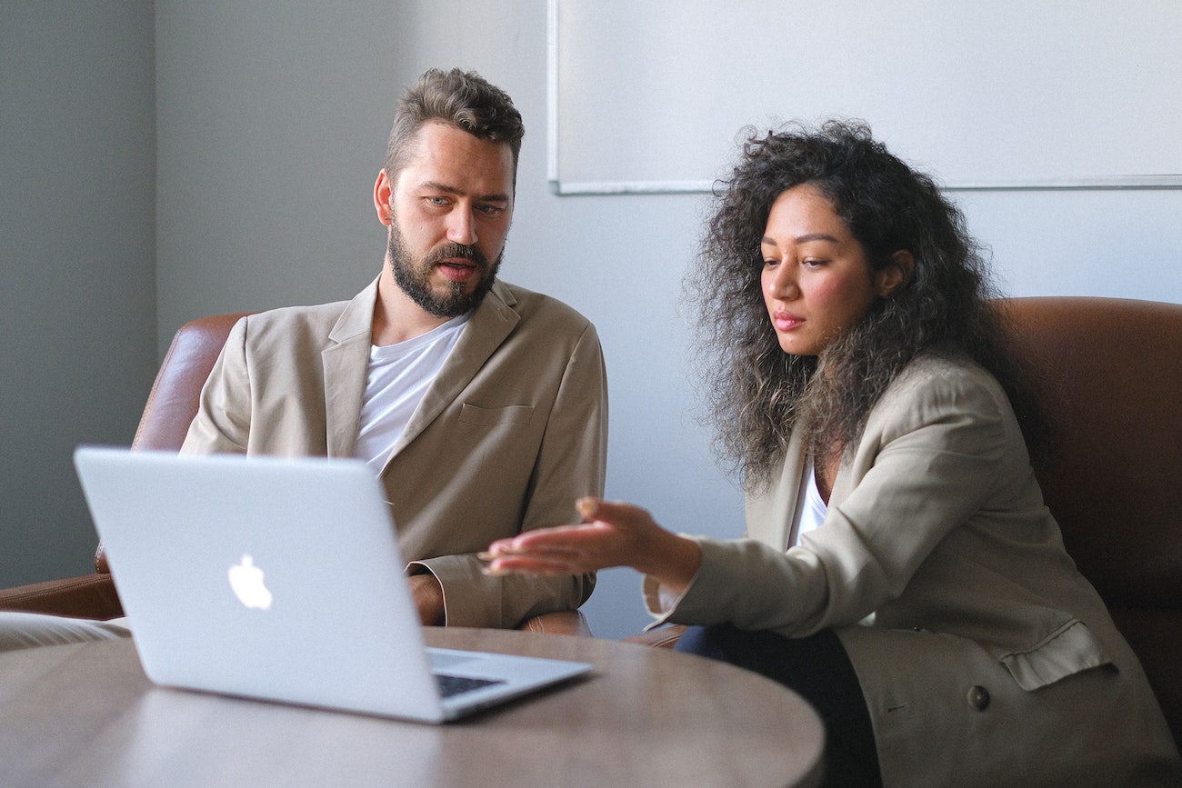 two employees at table with laptop