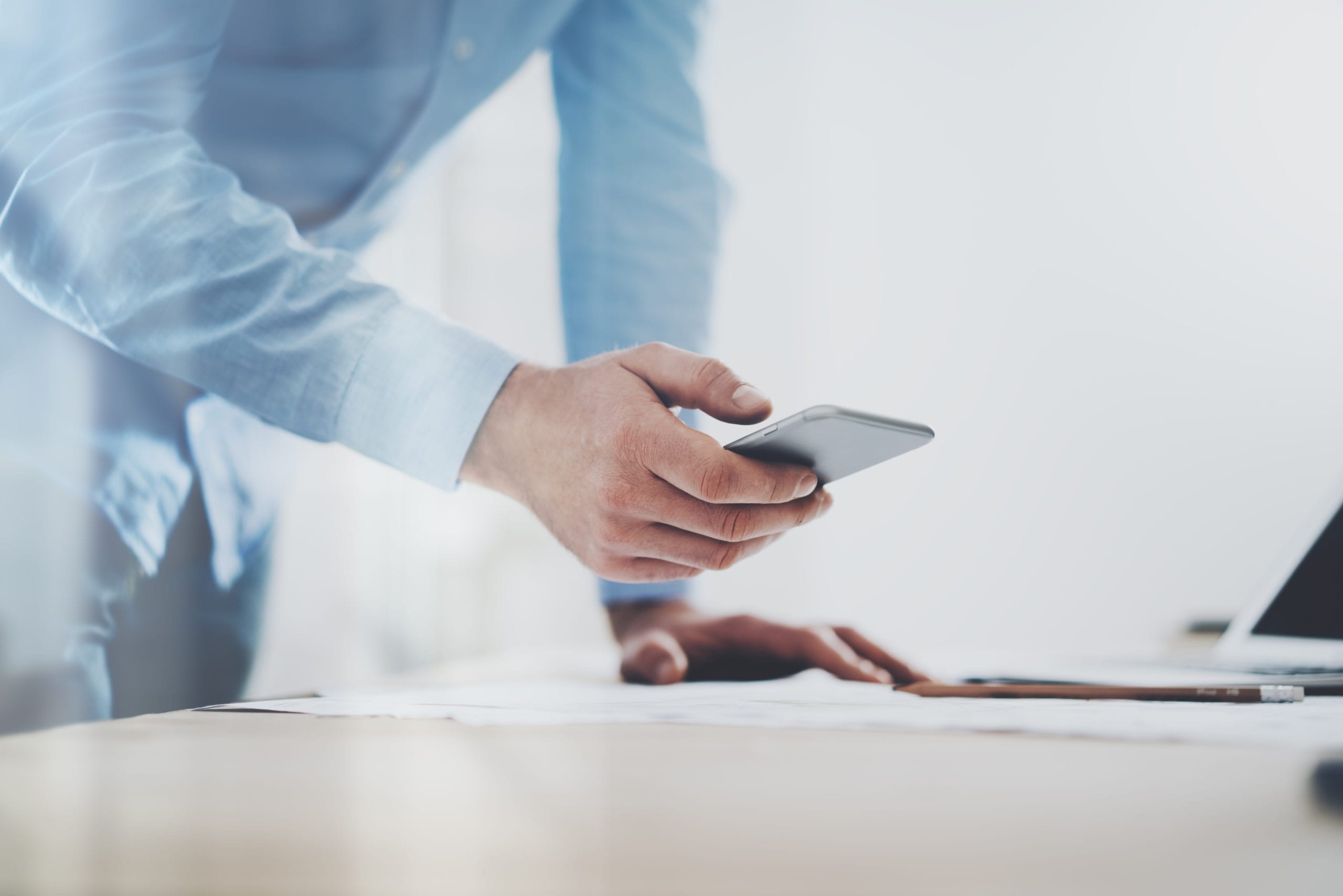 Man using phone to send push messages to employees