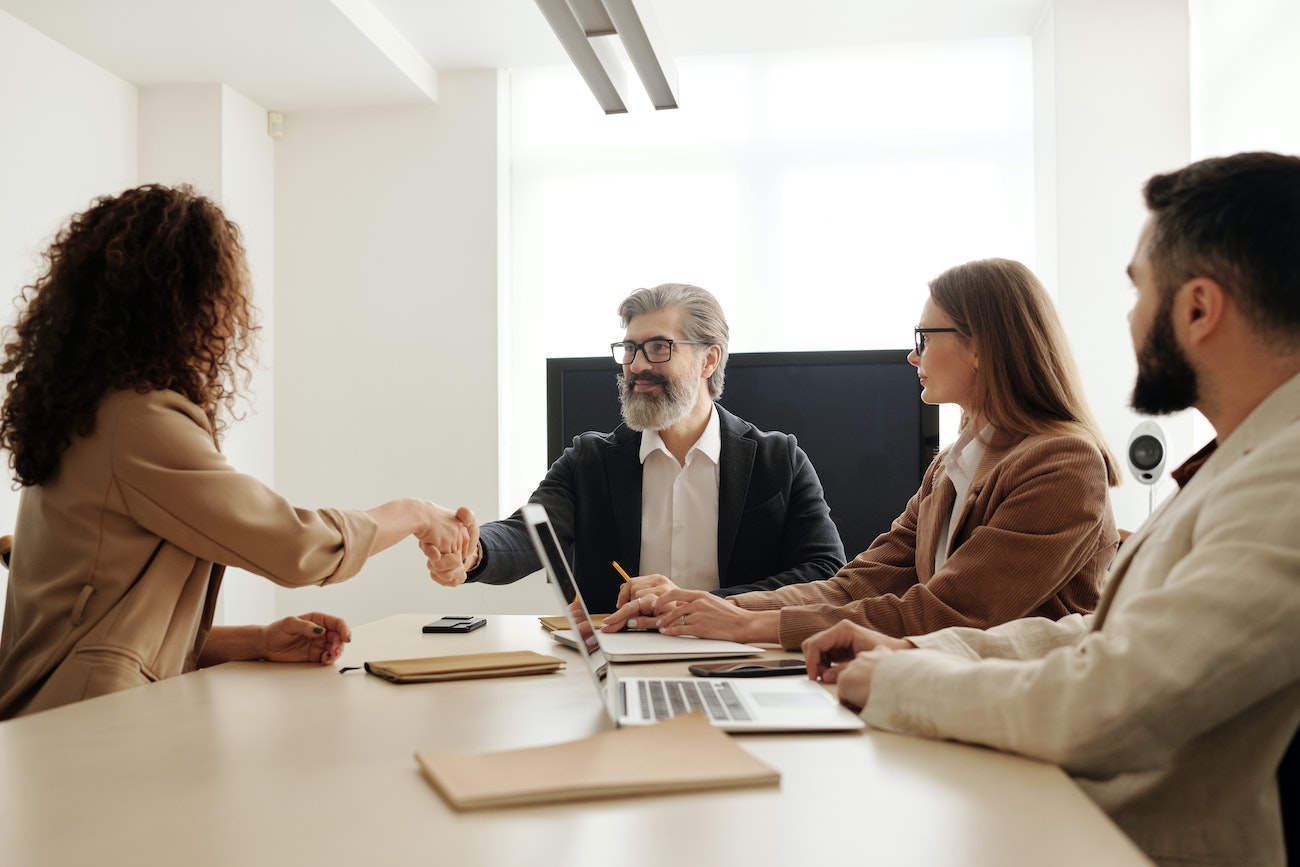 Employees at a table shaking hands